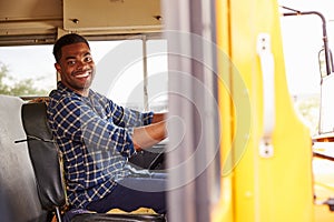 Smiling school bus driver sitting in bus