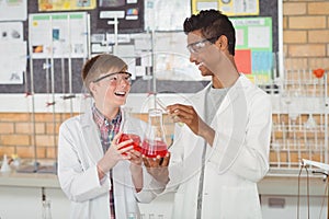 Smiling school kids doing a chemical experiment in laboratory