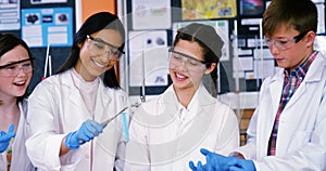 Smiling school kids doing a chemical experiment in laboratory