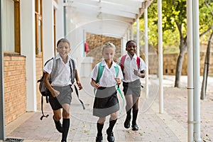 Smiling school kids running in corridor