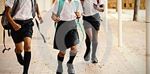 Smiling school kids running in corridor