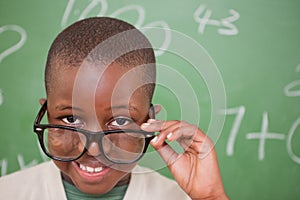 Smiling schoolboy looking over his glasses