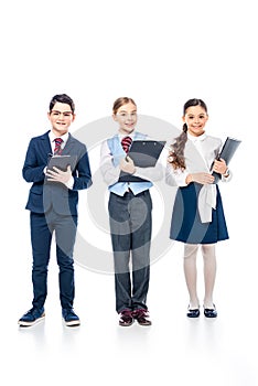 Smiling schoolchildren with clipboards pretending to be businesspeople On White.