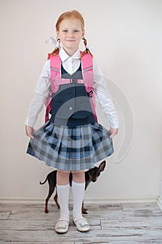 Smiling schoolgirl and dog indoors