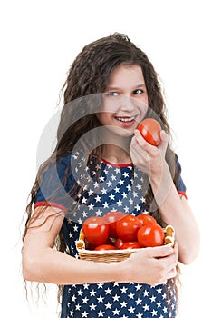 Smiling schoolgirl holds basket of tomato