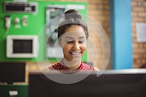 Smiling schoolgirl studying in computer classroom