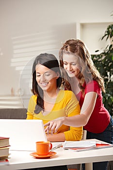 Smiling schoolgirls looking at screen photo