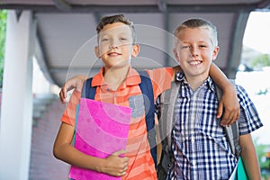 Smiling schoolkids standing in corridor