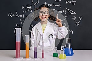 Smiling scientist child in lab coat having an idea