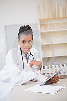 Smiling scientist looking at camera and holding tablet