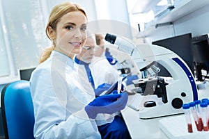 Smiling scientist sitting at a microscope