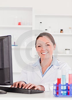 Smiling scientist typing a report