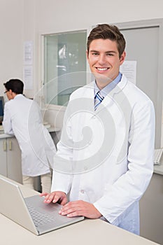 Smiling scientist using laptop