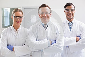 Smiling scientists looking at camera arms crossed