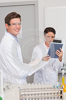 Smiling scientists using tablet