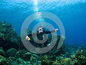 Smiling Scuba Diver descending on a Reef