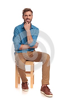 Smiling seated casual man is thinking