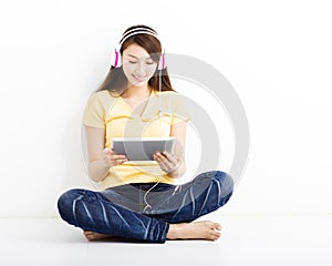 Smiling seated young woman with tablet pc