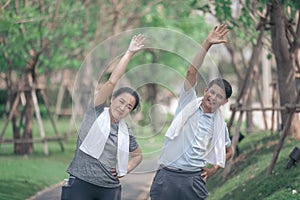 Smiling senior active couple exercise jogging together in the park