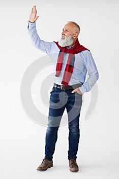 Smiling senior bearded man waving for someone on sideway