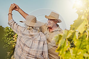 Smiling senior couple dancing together and feeling playful on vineyard. Caucasian husband and wife standing together and