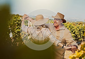 Smiling senior couple dancing together and feeling playful on vineyard. Caucasian husband and wife standing together and