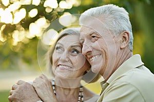 Smiling senior couple embracing in autumn park