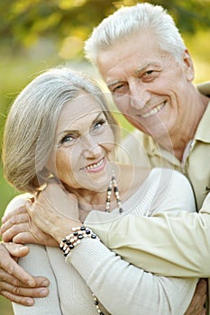 Smiling senior couple embracing in autumn park