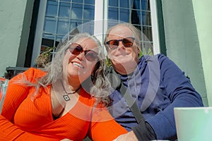 Smiling senior couple hugging enjoying a sunny day on terrace