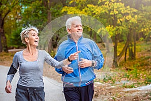 Smiling senior couple jogging in the park