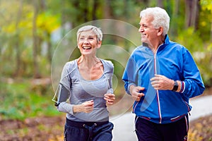 Smiling senior couple jogging in the park