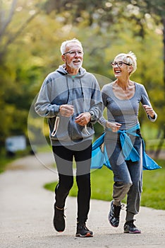 Smiling senior couple jogging in the park