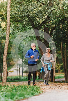 Smiling senior couple jogging in the park