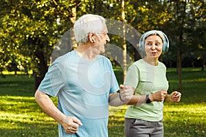 Smiling senior couple jogging in the park. Lifestyle and sport concept.