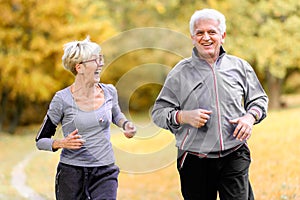 Smiling senior couple jogging in the park