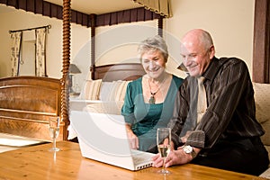 Smiling senior couple with laptop