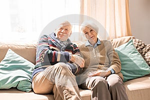 Smiling Senior Couple Posing on Sofa in Sunlight