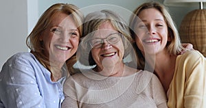 Smiling senior grandma aged mother millennial daughter posing for portrait