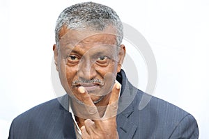 Smiling senior Indian man portrait showing victory sign on white background.