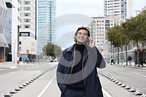 Smiling senior man, businessman talking on the phone while walking around the city