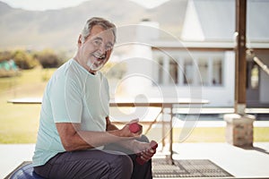 Smiling senior man exercising with dumbbells