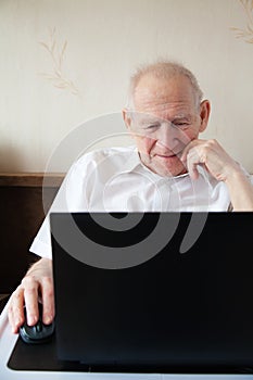 Smiling Senior Man In Front Of the Laptop