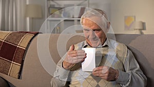 Smiling senior man hugging photo, remembering pleasure family moments, love