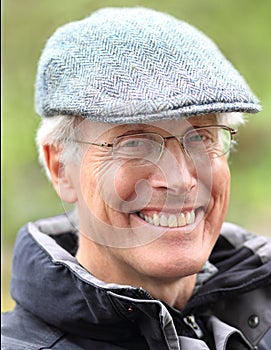 Smiling Senior Man Outdoors with Glasses and Cap