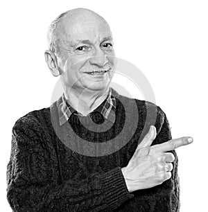 Smiling senior man pointing his finger to the side