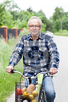 Smiling senior man riding a bicycle