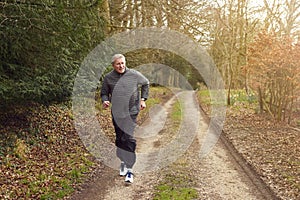 Smiling Senior Man Running In Autumn Countryside Exercising During Covid 19 Lockdown