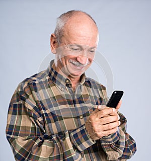 Smiling senior man in shirt talking on the mobile phone