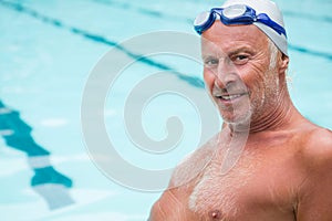 Smiling senior man sitting at poolside