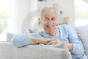 Smiling senior man on sofa